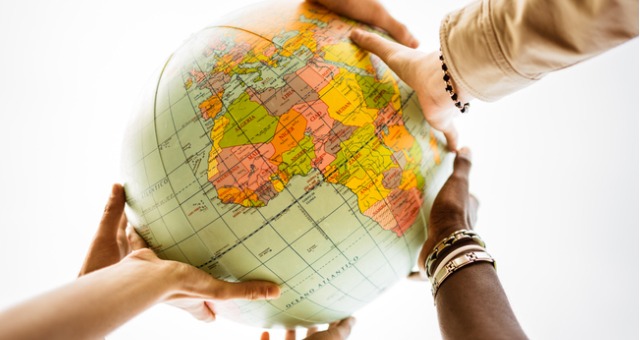 Students from different ethnicity hold globe to represent international students