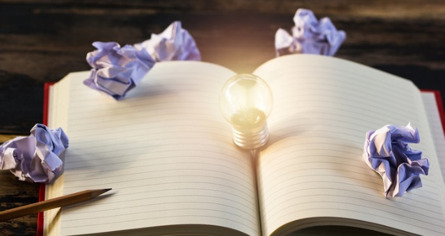 Blank notebook with idea lightbulb emerging from it