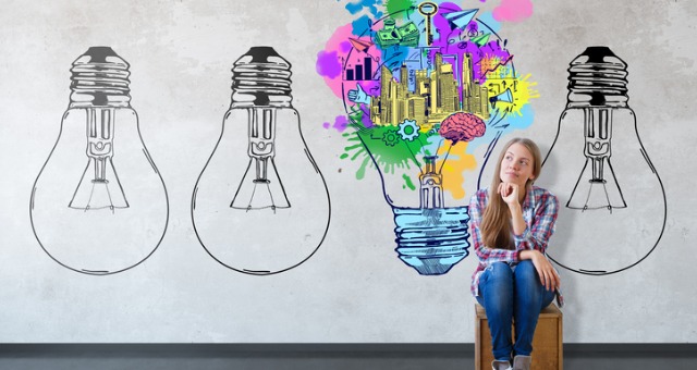Girl sits with light bulbs, including one full of ideas for redesigning an online class