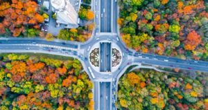 Roundabout features cars driving during fall and fall colored trees