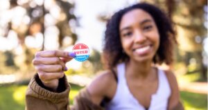 Young student holds up "I voted today" sticker