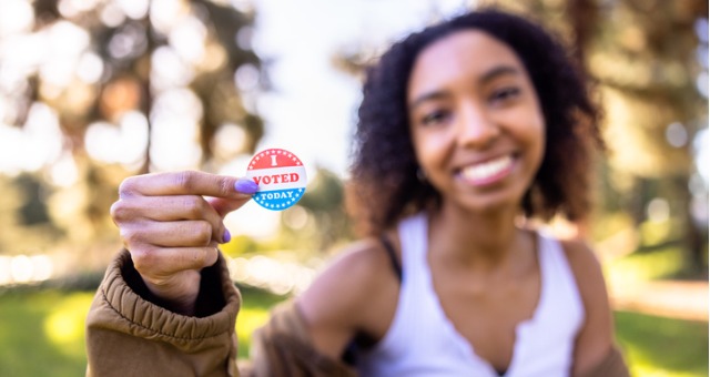 Young student holds up "I voted today" sticker