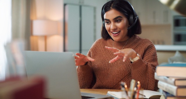 Woman talking on the computer with a headset and smiling