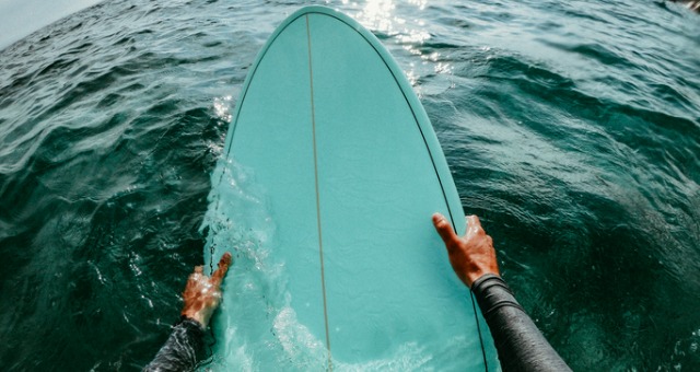 Person holding onto their surfboard in the ocean