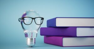 Lightbulb with glasses next to a stack of books