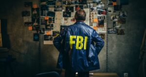 FBI agent standing in front of photos