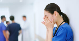 asian depressed female nurse is upset and medical team are discussing solutions in hospital