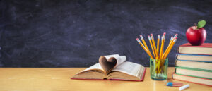 Stack Books And Pencils in Shape of Heart With Chalkboard