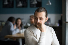 Shy student feeling anxious sitting alone in classroom