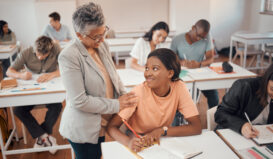 Teacher and shy student and classroom for test, knowledge and learning for higher education. Shy young female, black woman or educator helping pupil in exams, talking or students writing notes in books or focus