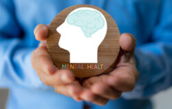 Mental health awareness, human hand care and support hold white paper head and glowing brain with physical and mental health, wellbeing, brain health, psychological support, healthcare and mindfulness