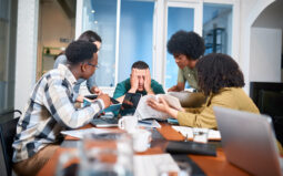 A diverse group of students in a classroom cooperate to tackle a complex project. Energetic discussions illustrate teamwork, brainstorming, and problem-solving in a classroom setting.