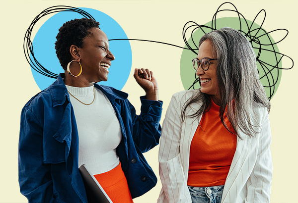 Two individuals talking to one another and laughing, with abstract art behind them
