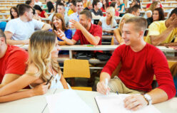 Group of students sitting and talking. The focus is on the foreground. First day of class.